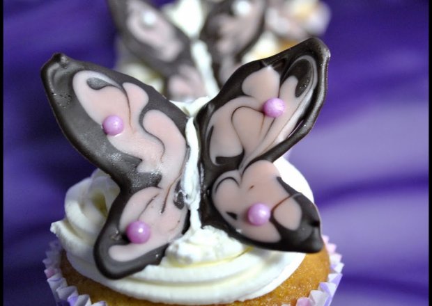 Fotografia przedstawiająca Babeczki z białą czekoladą i czekoladowe motyle
