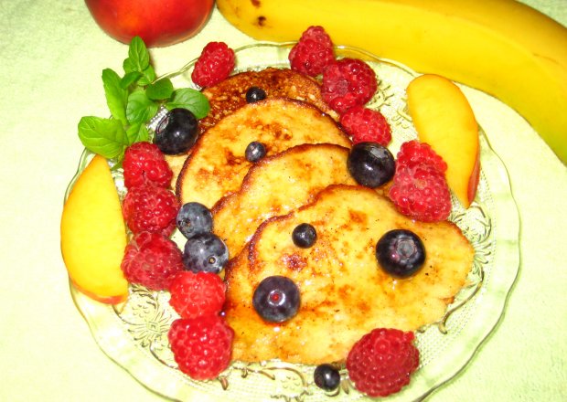 Fotografia przedstawiająca Bananowe placuszki z miodem i owocami.