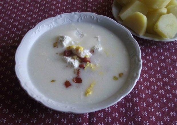Fotografia przedstawiająca Biały barszcz na kiełbasie  podany z białym serem  i ziemniakami