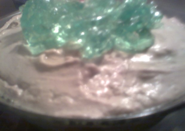 Fotografia przedstawiająca bita śmietana z zieloną galaretką