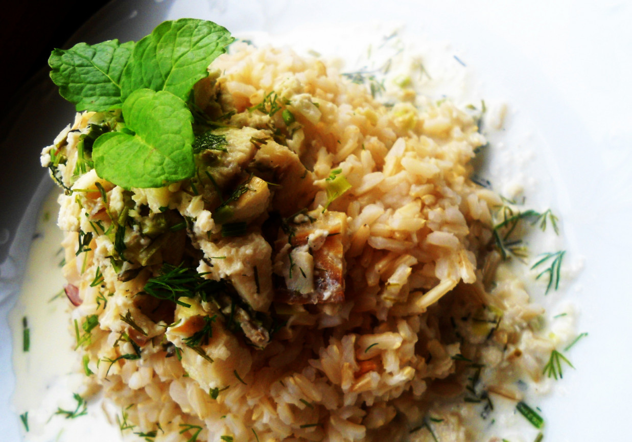 Brązowy ryż z gulaszem śmietanowym z dorsza, koperku, szczypiorku i natki pietruszki foto