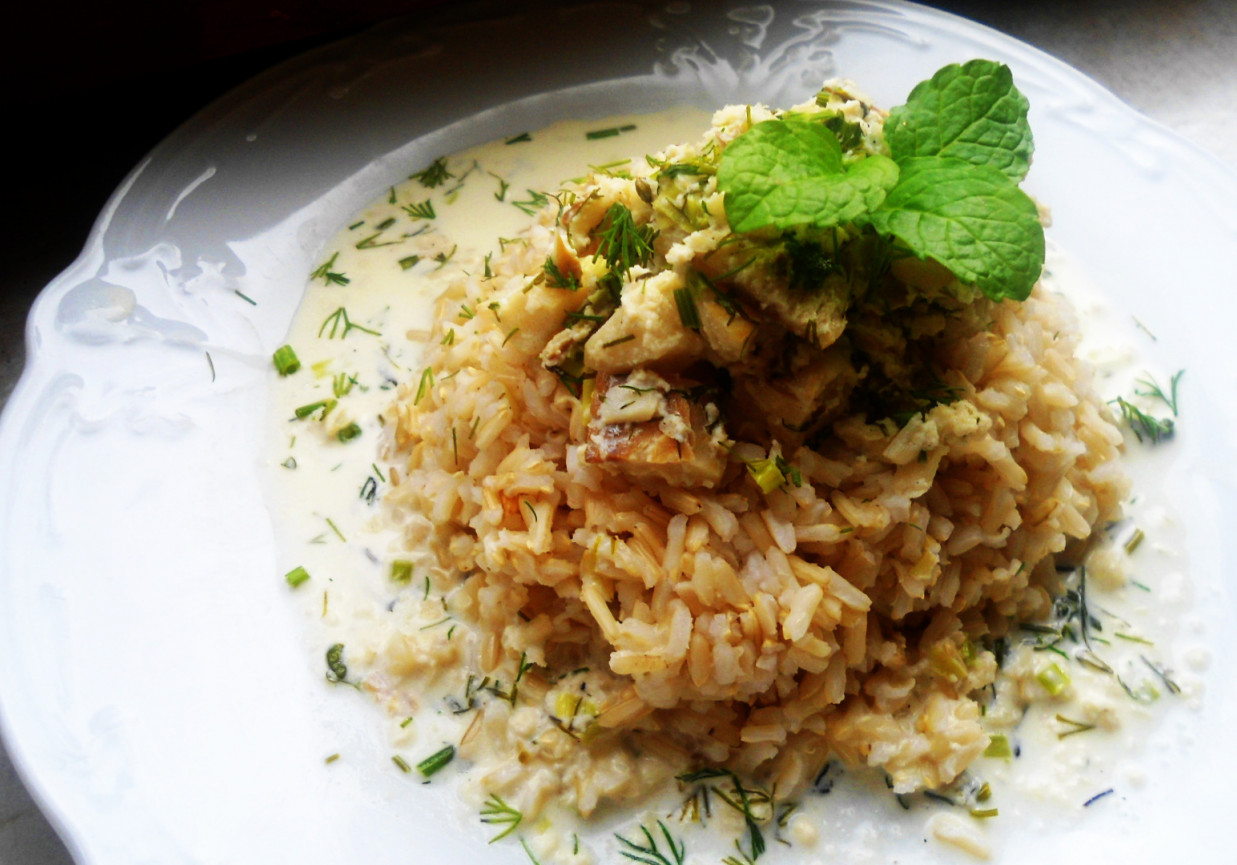 Brązowy ryż z gulaszem śmietanowym z dorsza, koperku, szczypiorku i natki pietruszki foto