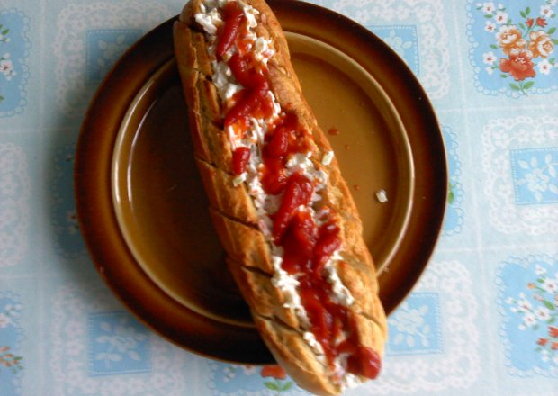 Fotografia przedstawiająca Bułka czosnkowa z sałatką i ketchupem