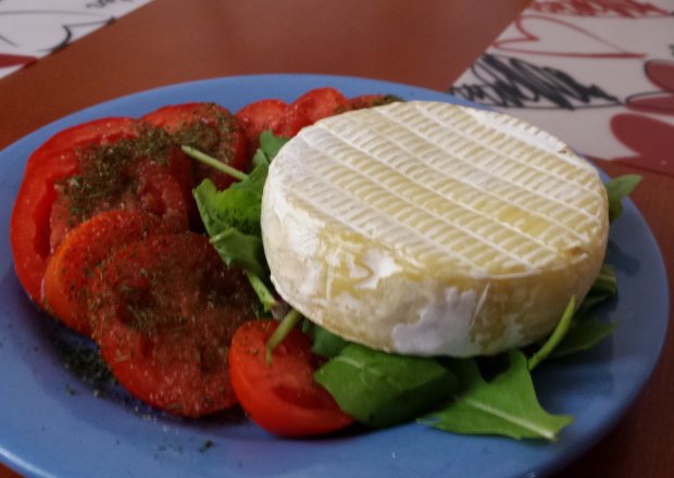 Fotografia przedstawiająca Camembert na sałacie z pomidorem i bazylią