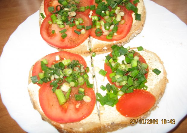 Fotografia przedstawiająca chleb z serem i pomidorem w jajku