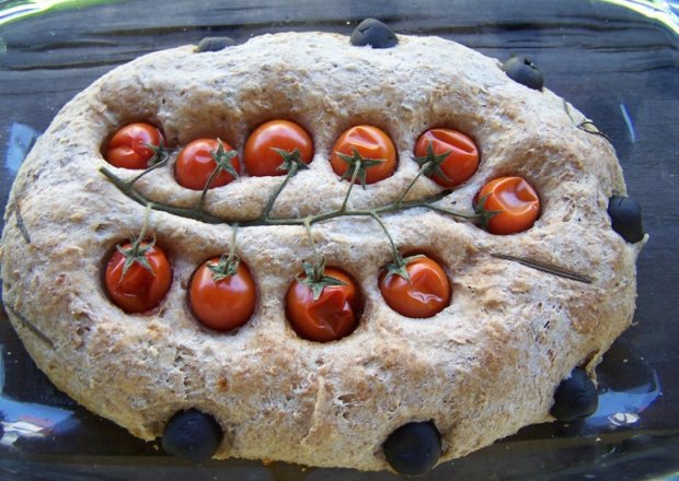 Fotografia przedstawiająca chlebek nadziewany serem feta i pomidorkami cherry