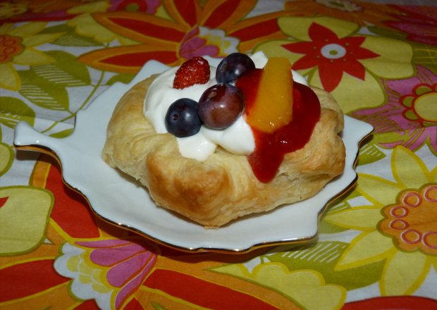 Fotografia przedstawiająca ciasteczka z owocami, musem truskawkowym i bitą śmietaną