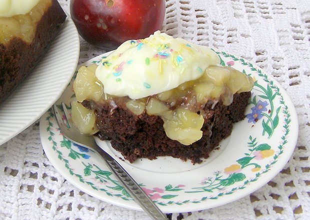 Fotografia przedstawiająca ciasto bez jajek czekoladowe z jabłkami budyniowymi z kleksami budyniu...