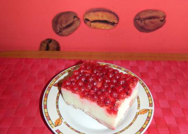 Fotografia przedstawiająca Ciasto bez pieczenia z czerwonymi porzeczkami w galaretce na herbatnikach z kaszą manną.