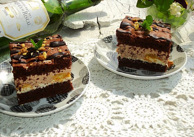 Fotografia przedstawiająca Ciasto czekoladowe z bitą śmietaną i biszkoptami
