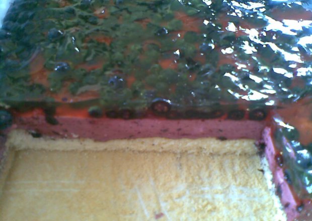 Fotografia przedstawiająca ciasto jagodowe z bitą śmietaną