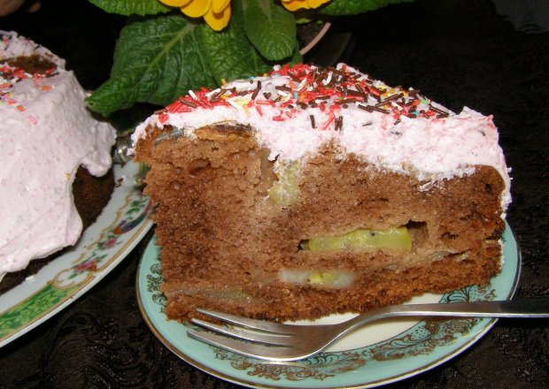 Fotografia przedstawiająca ciasto kakaowe z owocami i śmietaną galaretkową...