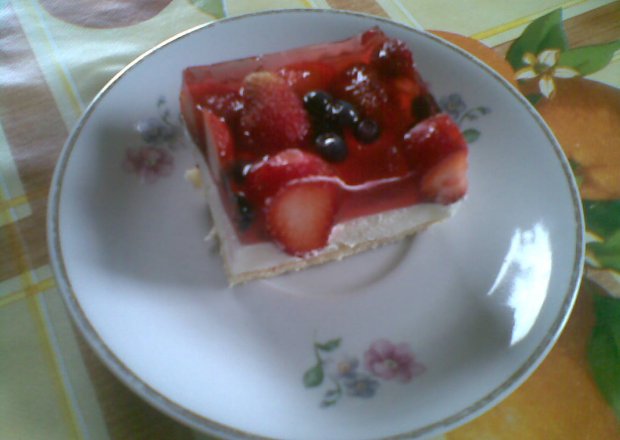 Fotografia przedstawiająca ciasto truskawkowo - jagodowe na biszkopcie