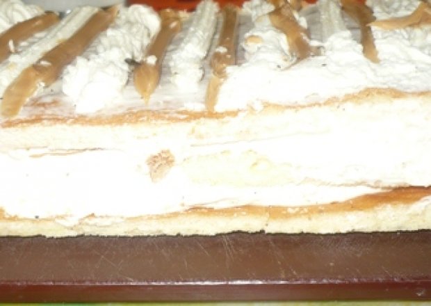 Fotografia przedstawiająca ciasto z bitą śmietaną  i masą krówkową