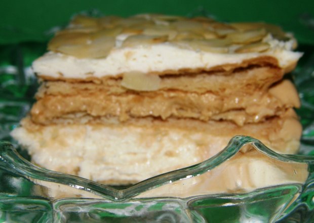Fotografia przedstawiająca ciasto z herbatnikami bitą śmietaną i migdałami