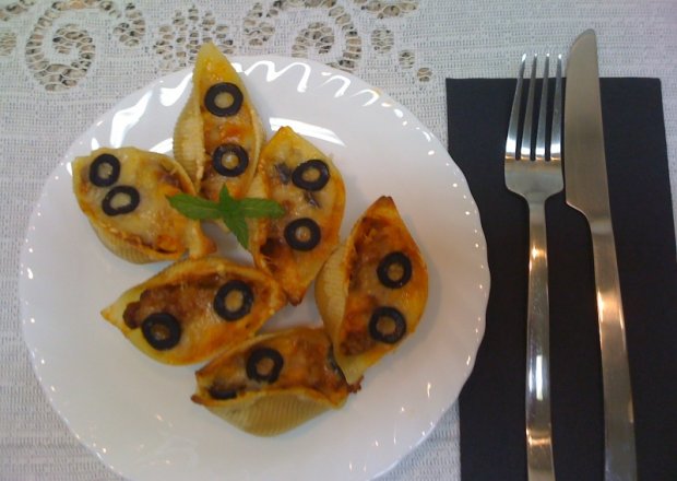 Fotografia przedstawiająca Conchiglioni zapiekane z pomidorowym mięsnym farszem pod żółtym serem