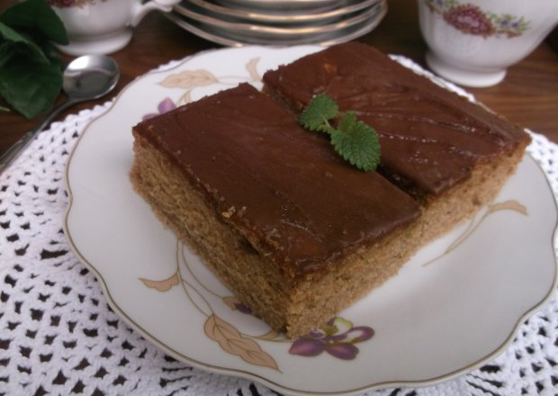 Fotografia przedstawiająca Cynamonowo-śmietankowe ciasto z polewą czekoladową.