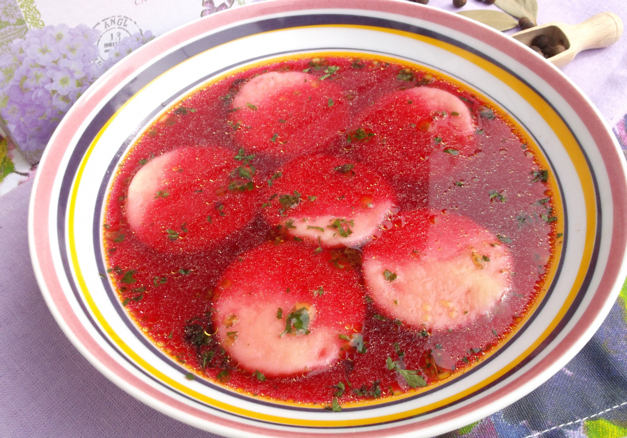 Czerwony barszczyk z kółeczkami z ciasta ziemniaczanego. foto