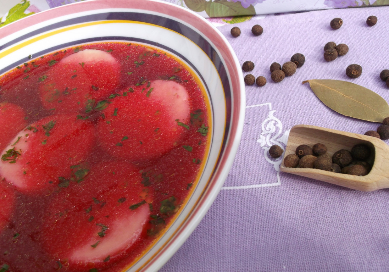 Czerwony barszczyk z kółeczkami z ciasta ziemniaczanego. foto