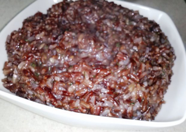 Fotografia przedstawiająca czerwony ryż  w maśle czosnkowo- koperkowym