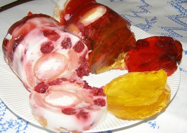 Fotografia przedstawiająca deser galaretkowy z wiśniami z butelki...