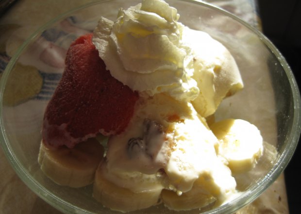 Fotografia przedstawiająca deser lodowy z bananami i śmietaną