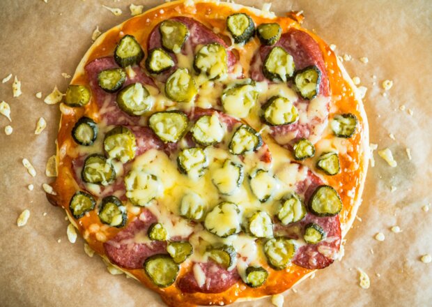 Fotografia przedstawiająca Domowa pizza z kiełbasą śląską i ogórkiem kiszonym