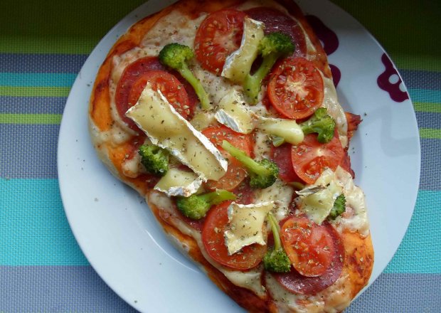 Fotografia przedstawiająca Domowa pizza z salami, pomidorem, camembertem i brokułami