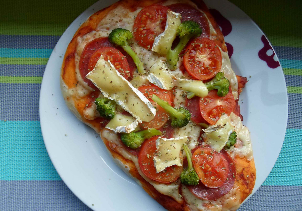 Domowa pizza z salami, pomidorem, camembertem i brokułami foto