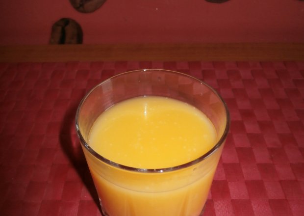 Fotografia przedstawiająca Drink na bazie ajerkoniaku z wódką i sokiem cytrynowym i pomarańczowym.