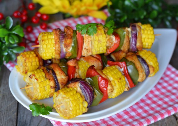 Fotografia przedstawiająca Drobiowe szaszłyki z kolorową papryką i kolbami kukurydzy