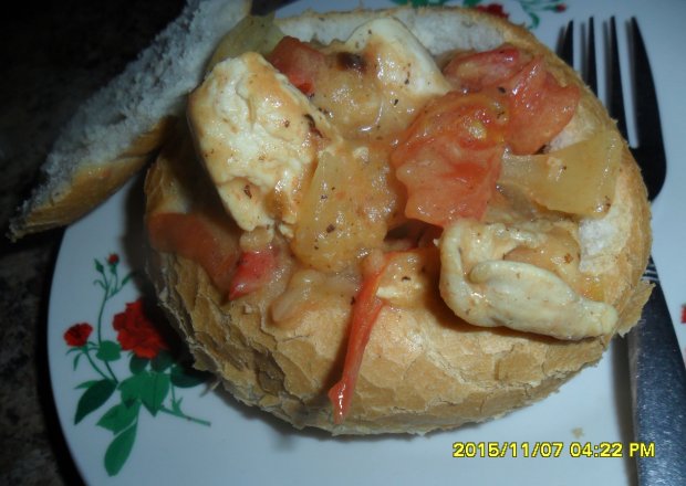 Fotografia przedstawiająca Duszony filet z kurczaka z sosem podany w bułce