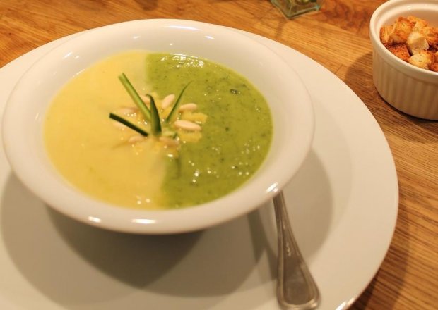 Fotografia przedstawiająca Dwukolorowa zupa krem z cukinii z serem Provolone i orzeszkami pini