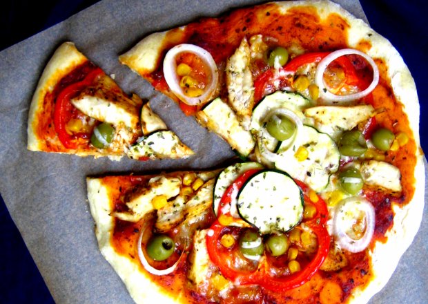 Fotografia przedstawiająca Farmerska pizza z pikantnym kurczakiem, cukinią, kukurydzą, papryką z dodatkiem oliwek