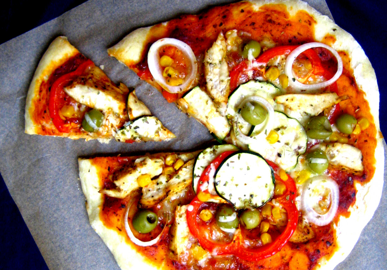 Farmerska pizza z pikantnym kurczakiem, cukinią, kukurydzą, papryką z dodatkiem oliwek foto
