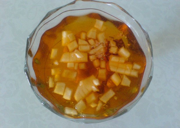 Fotografia przedstawiająca Galaretka pomarańczowa z kawałkami jabka, orzechów