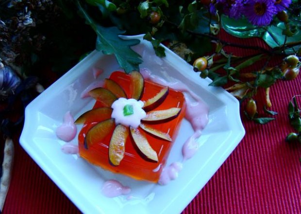 Fotografia przedstawiająca Galaretka pomarańczowa z sosem owocoowym i śliwkami