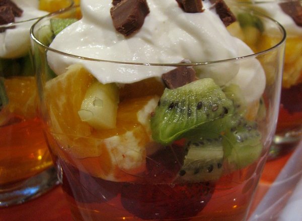 Fotografia przedstawiająca Galaretkowy deser z owocami i bitą śmietaną