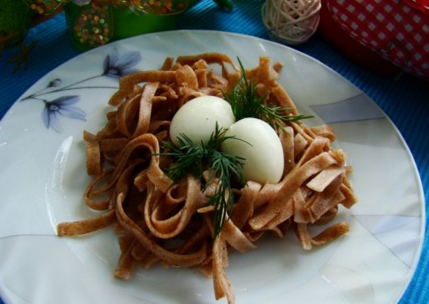 Fotografia przedstawiająca Gniazdko z razowego makaronu podane z jajkiem przepiórczym .