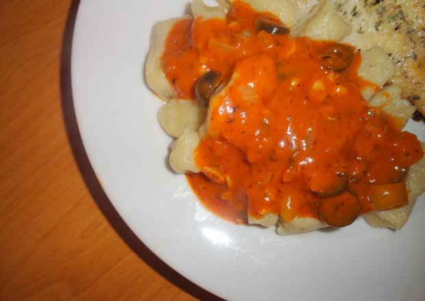 Fotografia przedstawiająca Gnocchi ziemniaczane z sosem pomidorowym z czarnymi oliwkami