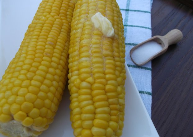 Fotografia przedstawiająca Gotowana kukurydza podana z masłem i solą.