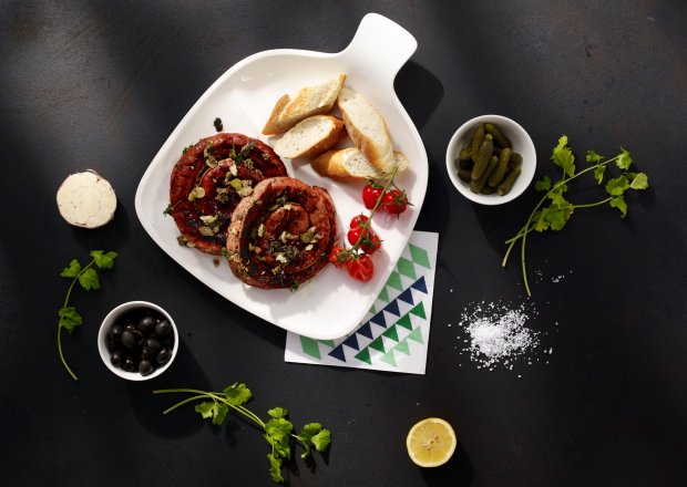 Fotografia przedstawiająca Grillowana kiełbasa z pieca z tapenade z czarnych oliwek i suszonych pomidorów