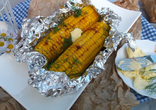 Fotografia przedstawiająca Grillowana kukurydza z masłem, papryką i koperkiem.