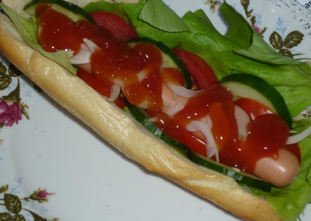 Fotografia przedstawiająca Hot dogi z sałatą, pomidorem i ogórkiem