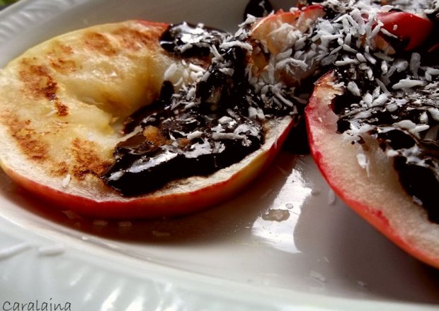 Fotografia przedstawiająca jabłka z grilla z sosem czekoladowym i kokosem
