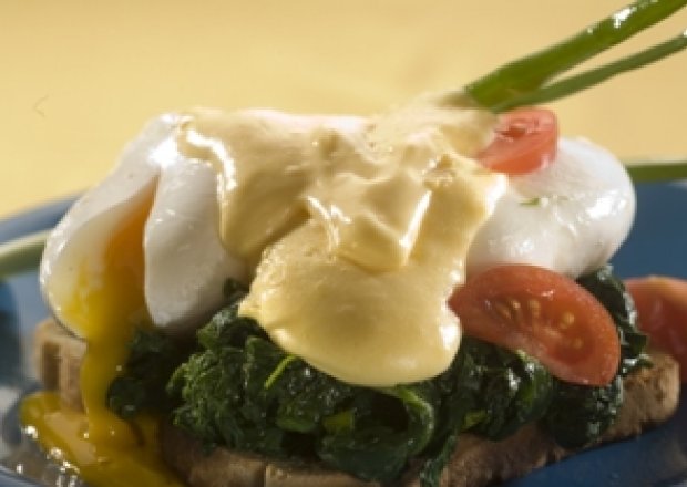 Fotografia przedstawiająca Jajka po benedyktyńsku ze szpinakiem i sosem holenderskim