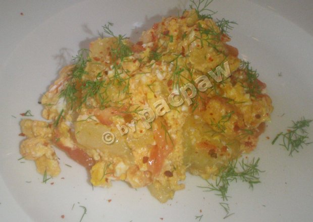 Fotografia przedstawiająca Jajka smażone z plasterkami ziemniaków i pomidorem