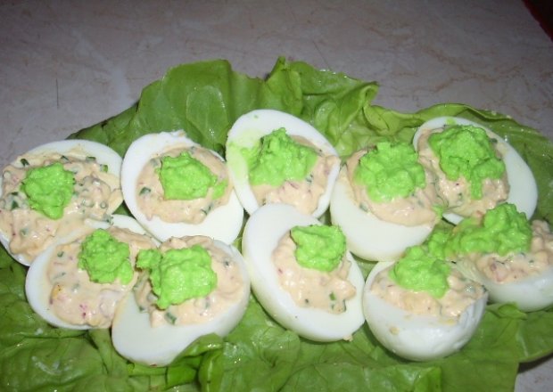 Fotografia przedstawiająca jajka z zielonym sosem