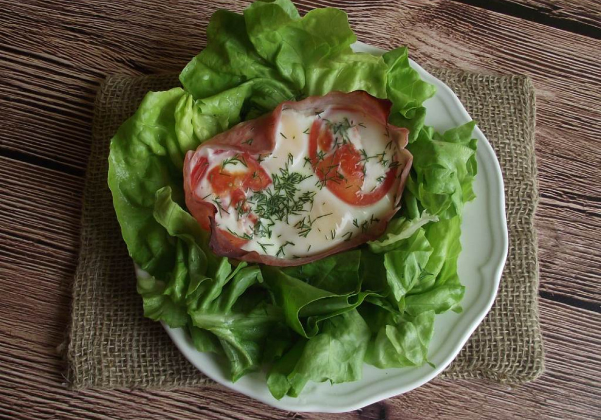 Jajka zapiekane w szynce z pomidorem i koperkiem podane na sałacie  foto
