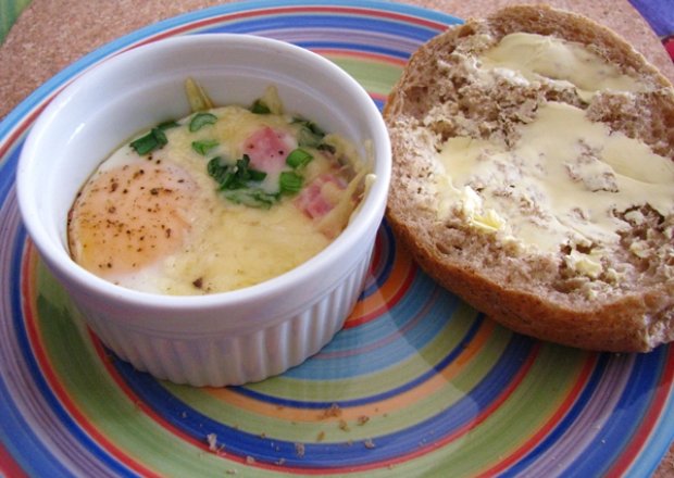 Fotografia przedstawiająca Jajka zapiekane z szynką, szczypiorem i serem